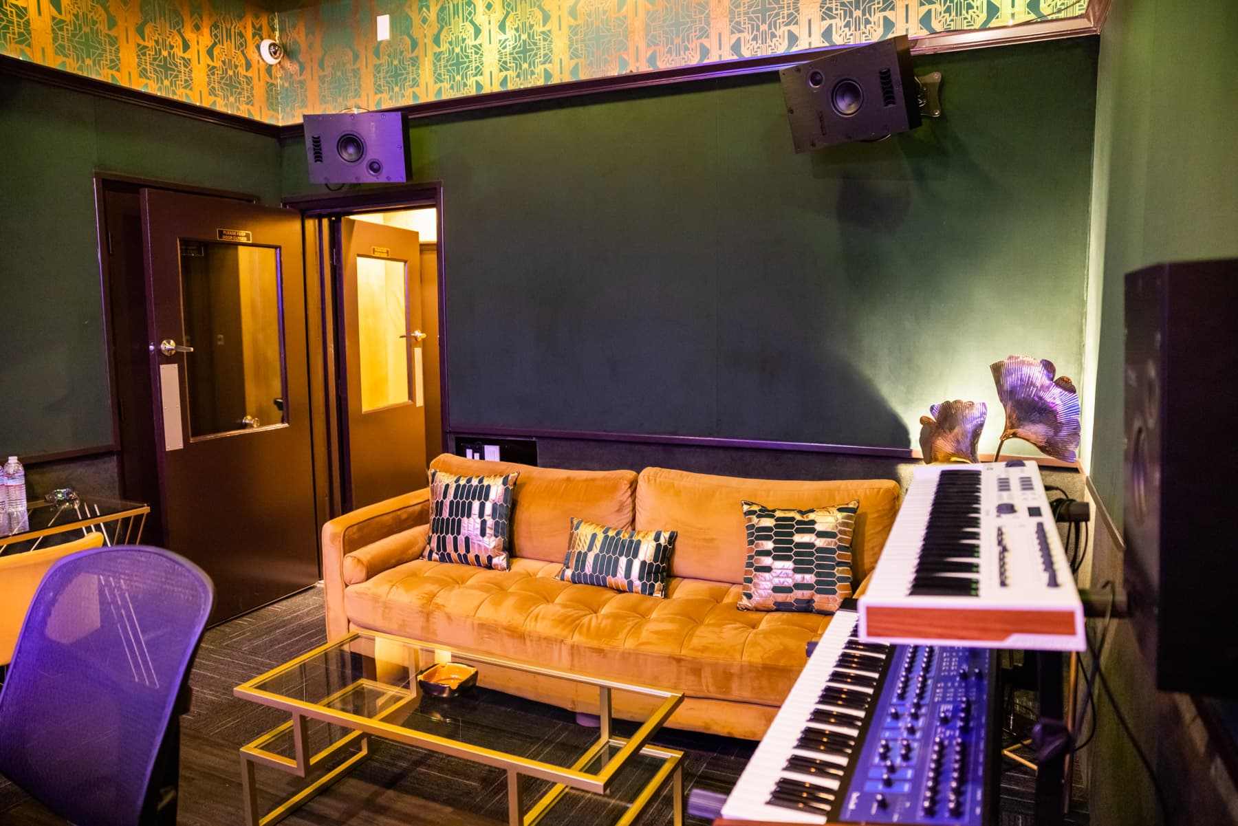 Studio B working space — couch and synth station with PMC monitoring overhead.